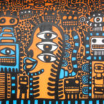 Mural on a street in Croydon, London in blue, light brown, black and cyan colors. A busy image with many different figures that are both humanoid and rectangular/robotic. A central image has three large eyes arranged vertically.